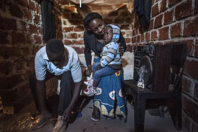 Sidiki Mayamba, left, puts on his shoes in the room he shares with his wife Ivette Mujombo Tshatela and their 2-year-old son Harold Muhiya Mwehu in Kolwezi on June 10, 2016. Mayamba is a “creuseur”, or digger who works in the cobalt and copper mines that surround Kolwezi. He says he works in harsh conditions to bring home $2-3/day. Mayamba and his family rent part of an unfinished home and have no electricity or running water. (Photo by Michael Robinson Chavez/The Washington Post)