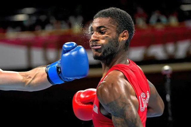 USA's Delante Marquis Johnson (red) takes a punch from Argentina's Brian Agustin Arregui during their men's welter (63-69kg) preliminaries boxing match during the Tokyo 2020 Olympic Games at the Kokugikan Arena in Tokyo on July 24, 2021. (Photo by Frank Franklin II/Pool via AFP Photo)
