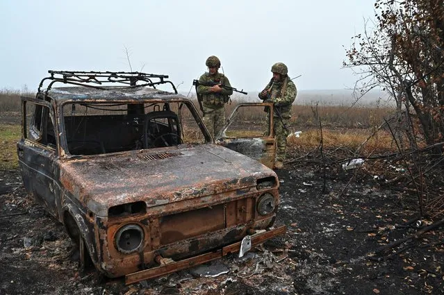 Ukrainian servicemen inspect a destroyed vehicle outside the village of Robotyne, amid Russia's attack on Ukraine, near a front line in Zaporizhzhia region, Ukraine on November 4, 2023. (Photo by Reuters/Stringer)