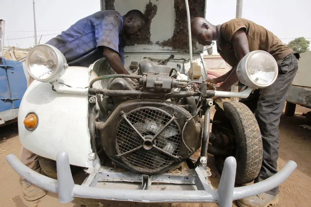 N'cote N'clo, also known as Babi Kouakou, (L) works with a mechanic apprentice in his car repair garage in Bouake, Ivory Coast February 9, 2016. (Photo by Thierry Gouegnon/Reuters)