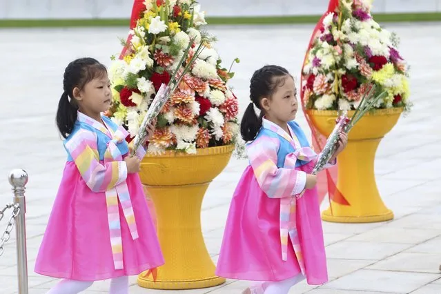 Children visit the statues of former leaders Kim Il Sung and Kim Jong Il on Mansu Hill in Pyongyang, marking North Korea’s 75th founding anniversary, on Saturday, September 9, 2023. (Photo by Cha Song Ho/AP Photo)