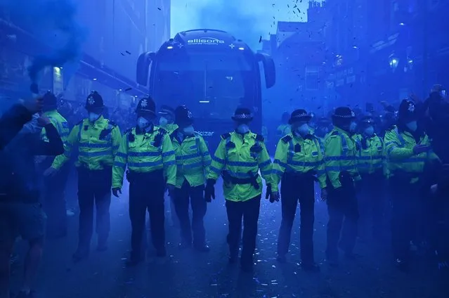 Police officers form a protective line as a team coach arrives ahead of the English Premier League football match between Everton and Manchester United at Goodison Park in Liverpool, north west England on October 9, 2022. (Photo by Oli Scarff/AFP Photo)