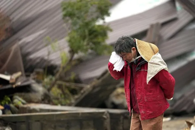 A man cries as a body of his family member was found from a collapsed house caused by powerful earthquake in Suzu, Ishikawa Prefecture Wednesday, January 3, 2024. A series of powerful earthquakes hit western Japan, damaging buildings, vehicles and boats, with officials warning people in some areas on Tuesday to stay away from their homes because of a risk of more strong quakes. (Photo by Hiro Komae/AP Photo)