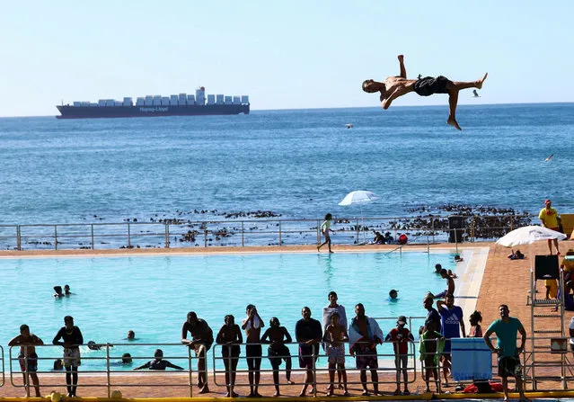 A person dives from a springboard during a hot summer day at Sea Point swimming pool in Cape Town, South Africa on January 8, 2024. (Photo by Esa Alexander/Reuters)