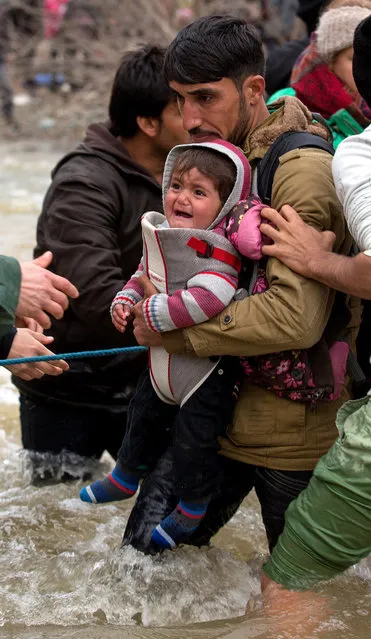 Migrants cross a river after leaving the Idomeni refugee camp on March 14, 2016 in Idomeni, Greece. (Photo by Matt Cardy/Getty Images)