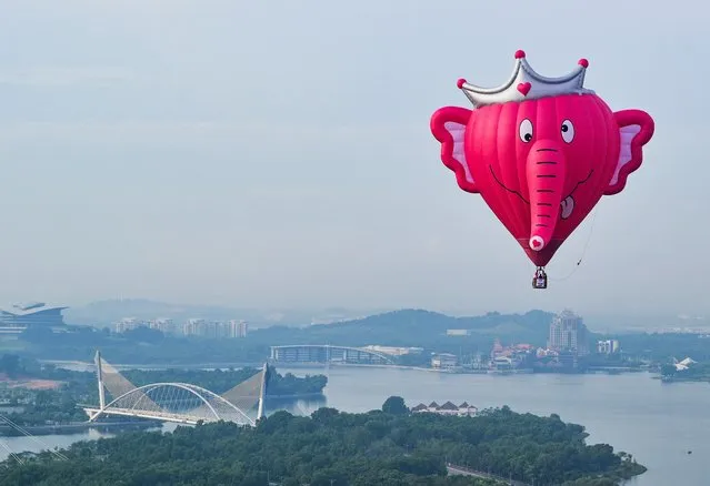 In this aerial photo taken on March 28, 2019 a hot air balloon flies over Putrajaya during the international hot air balloon festival in Putrajaya, Malaysia. (Photo by Mohd Rasfan/AFP Photo)