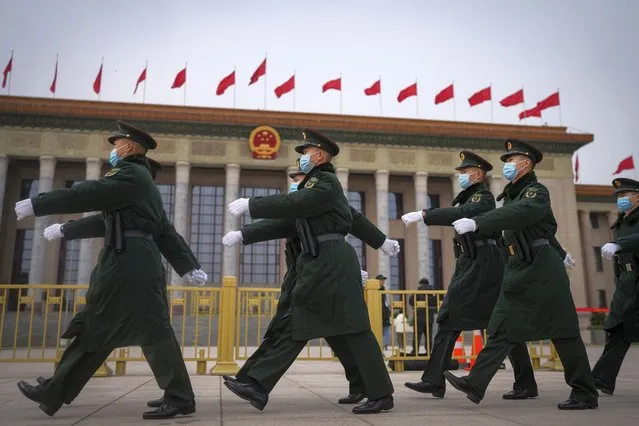 Chinese soldiers march past the Great Hall of the People during a preparatory session of the National People's Congress (NPC) in Beijing, Monday, March 4, 2024. (Photo by Andy Wong/AP Photo)