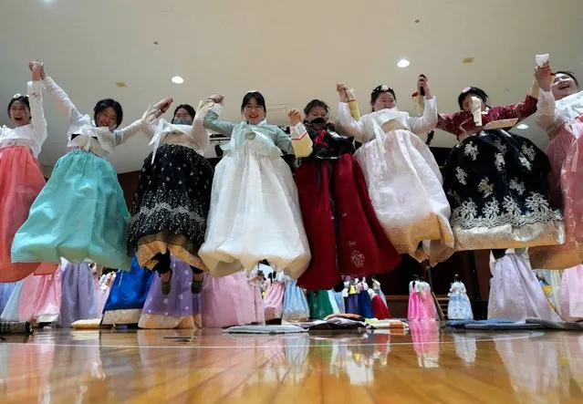 South Korean seniors clad in traditional attire jump to take photos after a joint graduation and coming-of-age ceremony at Dongmyung Girls' High School in Seoul, South Korea, Tuesday, February 6, 2024. (Photo by Ahn Young-joon/AP Photo)