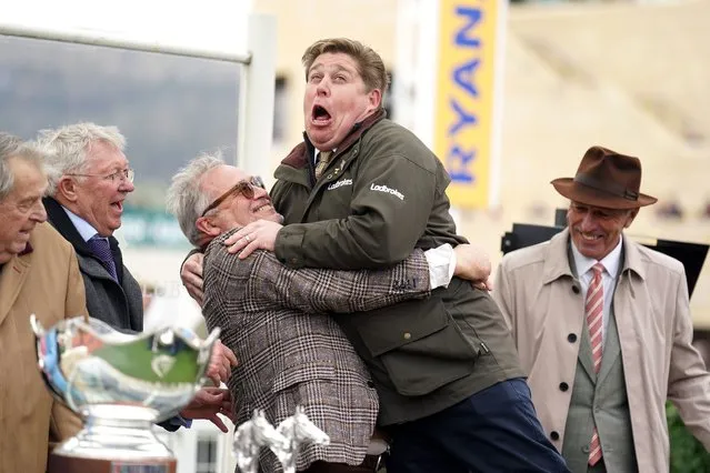 Dan Skelton celebrates with joint owner of Protektorat, Ged Mason, as Sir Alex Ferguson and John Hales look on following their victory in the Ryanair Steeple Chase on day three of the 2024 Cheltenham Festival at Cheltenham Racecourse on Thursday, March 14, 2024. (Photo by Mike Egerton/PA Images via Getty Images)