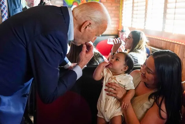 U.S. President Joe Biden mimics a baby during a campaign event at a Mexican restaurant in the Phoenix area, Arizona, U.S., March 19, 2024. (Photo by Kevin Lamarque/Reuters)