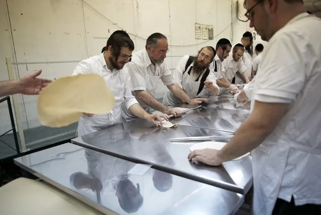 Ultra-Orthodox Jewish men prepare matza, traditional unleavened bread eaten during the upcoming Jewish holiday of Passover, in the southern city of Ashdod April 17, 2016. (Photo by Amir Cohen/Reuters)