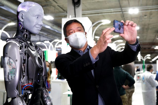 Journalist Mark Niu takes a selfie with Ameca, a humanoid robot by Engineered Arts, at the entrance to the UK Pavilion during CES 2022 in Las Vegas, Nevada, U.S. on January 6, 2022. (Photo by Steve Marcus/Reuters)