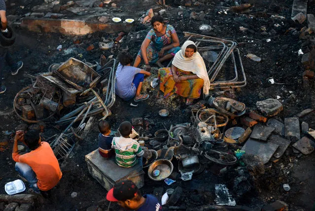 Indian slum dwellers look for their belongings after a fire broke out at their hutments in Amritsar on June 27, 2019. Hundred of hutments were burnt and no casualties reported in the incident, local reports said. (Photo by Narinder Nanu/AFP Photo)