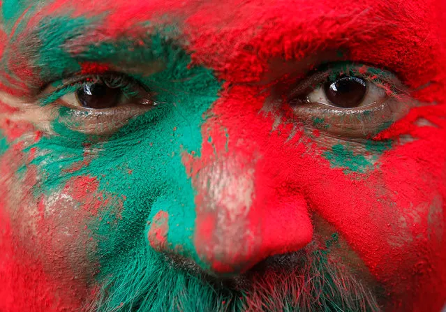 A Hindu devotee is covered in coloured powder as he stands outside a temple during the religious festival of Holi in Vrindavan, in the northern state of Uttar Pradesh, India, March 8, 2017. (Photo by Cathal McNaughton/Reuters)