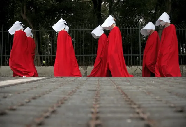 Activists dressed in Handmaid's Tale costumes walk as they take part in a demonstration to mark International Women's Day in Sao Paulo, Brazil on March 8, 2021. (Photo by Carla Carniel/Reuters)