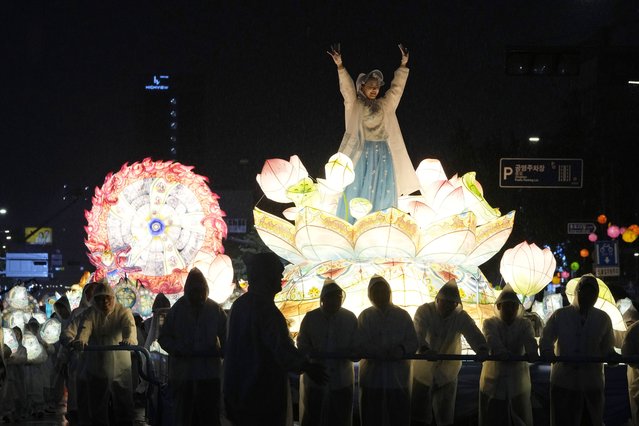A woman waves from a lantern float during the Lotus Lantern Festival ahead of the upcoming birthday of Buddha on May 15, on a street in Seoul, South Korea, Saturday, May 11, 2024. (Photo by Ahn Young-joon/AP Photo)