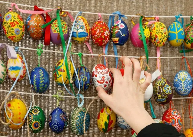A woman touches a traditional Ukrainian Easter egg “Pysanka”, which is on display as part of the upcoming celebrations of Easter, in central Kiev, Ukraine, April 29, 2016. (Photo by Valentyn Ogirenko/Reuters)