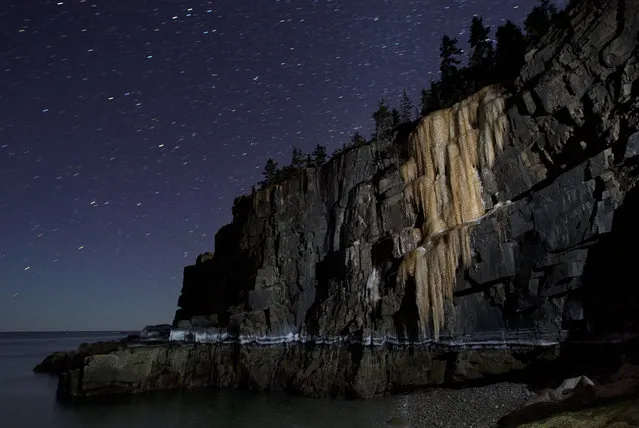 Like a frozen waterfall, a wall of ice more than 40-feet-high stretches down to the high-tide line on Otter Cliffs overlooking the Atlantic Ocean, at Acadia National Park in Maine, on March 6, 2014. (Photo by Robert F. Bukaty/Associated Press)