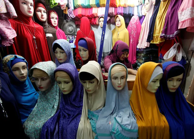 A woman selling hijab waits for costumers at Jatinegara Market in Jakarta, Indonesia, January 31, 2017. (Photo by Fatima El-Kareem/Reuters)