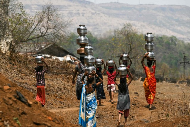 In this photo taken on May 24, 2024, villagers carry water pots in Shahapur district of India's Maharashtra state, amid ongoing heatwave. (Photo by Indranil Mukherjee/AFP Photo)