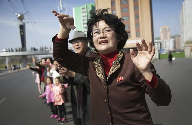 Sin Ye Suk, 50, a resident of Mirae Scientist Street stands in front of her apartment with fellow residents as they cheer on participants of the Pyongyang marathon on Sunday, April 9, 2017, in Pyongyang, North Korea. (Photo by Wong Maye-E/AP Photo)