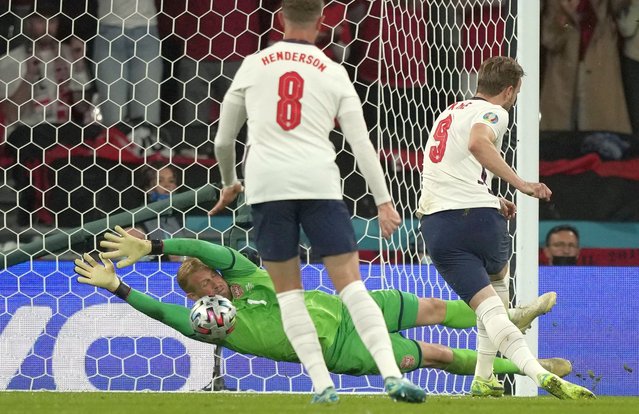 England's forward Harry Kane (R) shoots and scores a penalty kick past Denmark's goalkeeper Kasper Schmeichel (Back) during the UEFA EURO 2020 semi-final football match between England and Denmark at Wembley Stadium in London on July 7, 2021. (Photo by Frank Augstein/Pool via AFP Photo)