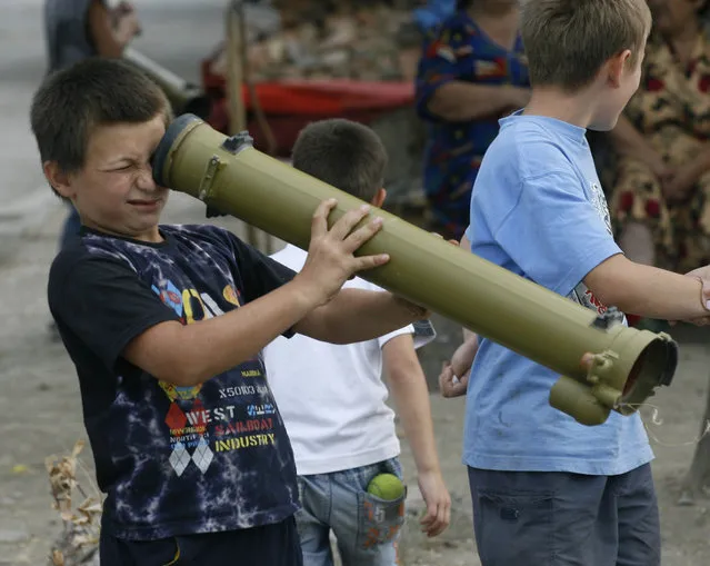 Children play with an empty grenade launcher in the South Ossetian city of Tskhinvali, Georgia September 1, 2008. (Photo by Sergei Karpukhin/Reuters)