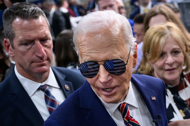 US President Joe Biden wears sunglasses given to him by supporters after speaking on the PACT Act, which expands coverage for veterans exposed to toxic substances, at the Westwood Park YMCA in Nashua, New Hampshire, on May 21, 2024. (Photo by Mandel Ngan/AFP Photo)