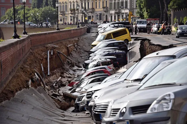 Cars are engulfed by a chasm which opened along Arno river near the Ponte Vecchio Old Bridge, in Florence, Italy, Wednesday,  May 25, 2016. According to reports, the collapse occurred early in the morning and is caused by the rupture of an acqueduct. No one was injured. (Photo by Maurizio degl'Innocenti/ANSA via AP Photo)