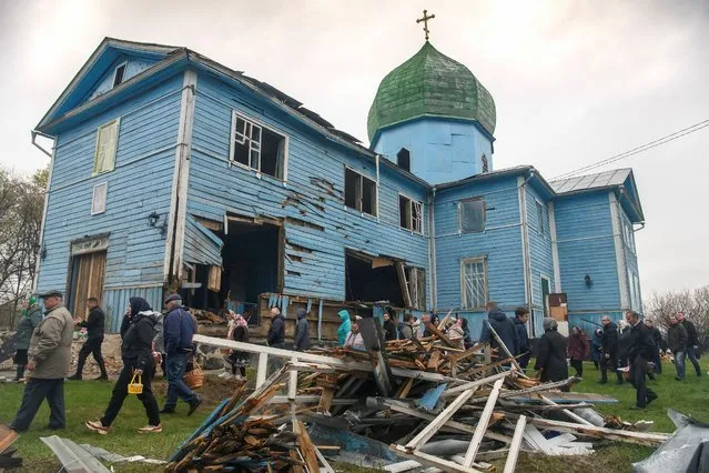 Local residents walk after the Orthodox Easter service next to The Nativity of the Holy Virgin Church damaged by shelling during Russia's invasion in the village of Peremoha, in Kyiv region, Ukraine April 24, 2022. (Photo by Vladyslav Musiienko/Reuters)