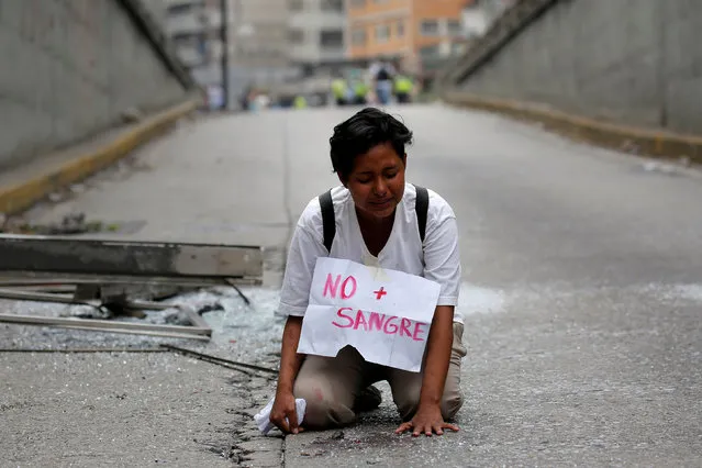 A woman kneels at the place where 17-year-old demonstrator Neomar Lander died during riots at a rally against Venezuelan President Nicolas Maduro's government in Caracas, Venezuela, June 8, 2017. The sign reads: “No more blood”. (Photo by Ivan Alvarado/Reuters)