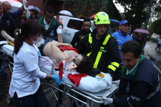 A woman is evacuated on a gurney after an explosion at the Centro Andino shopping center in Bogota, Colombia, Saturday, June 17, 2017. Authorities reported one woman was killed and 11 people injured. Authorities' attention immediately focused on the country's largest still active rebel group, the National Liberation Army, or ELN, which in February claimed responsibility for a bombing near Bogota's bullring that killed one police officer and injured 20 other people. (Photo by Ricardo Mazalan/AP Photo)