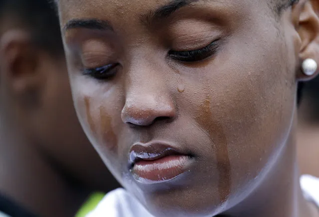 Tears roll down the face of a woman at a vigil outside of where a pregnant mother was shot and killed Sunday by police, Tuesday, June 20, 2017 in Seattle. Police officers shot and killed 30-year-old Charleena Lyles after Lyles, authorities said, confronted the officers with knives. (Photo by Elaine Thompson/AP Photo)