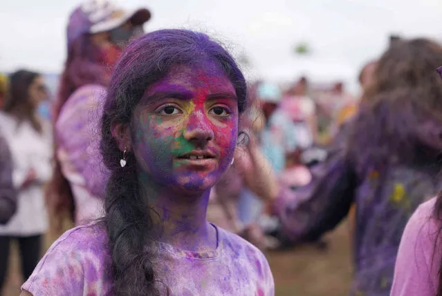 Revelers play with colors during a Festival of Colors procession at Bull Run Special Events Center, Sunday, May 1, 2022 in Centreville, Va. The festival features traditional Indian music, dancing, and a color run. (Photo by Mariam Zuhaib/AP Photo)