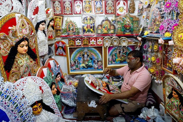 An artisan paints a decorative of the Hindu goddess Durga inside a shop ahead of the Durga Puja festival in Kolkata, India, on September 16, 2024. (Photo by Sahiba Chawdhary/Reuters)