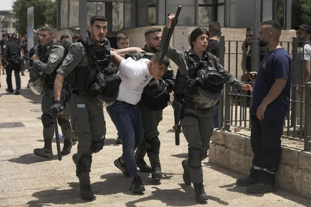 Members of Israeli security forces detain a Palestinian protester near Damascus Gate outside Jerusalem's Old City as Israelis mark Jerusalem Day, an Israeli holiday celebrating the capture of the Old City during the 1967 Mideast war. Sunday, May 29, 2022. (Photo by Mahmoud Illean/AP Photo)