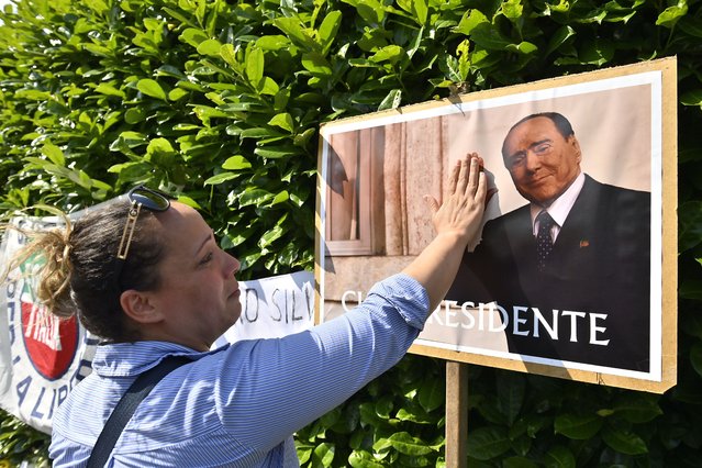 Crying woman touches a photo of Silvio Berlusconi outside the Villa San Martino on June 12, 2023 in Arcore, Italy. Silvio Berlusconi, the former Italian Prime Minister who bounced back from a series of scandals, died today at age 86, according to Italian news reports. (Photo by Stefano Guidi/Getty Images)