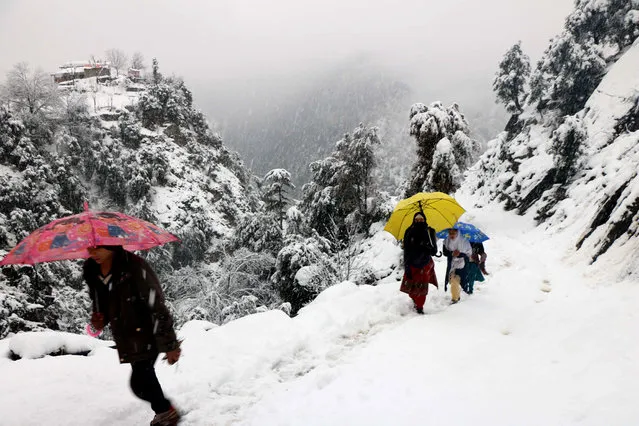 People walk during snowfall in Neelum Valeey, in Pakistani administered Kashmir, 13 January 2020. Reports state that many cities in Pakistan are experiencing unusual cold weather conditions during which regular daytime temperatures fall below zero degree Celsius in wide parts of the country. (Photo by Amiruddin Mughal/EPA/EFE)