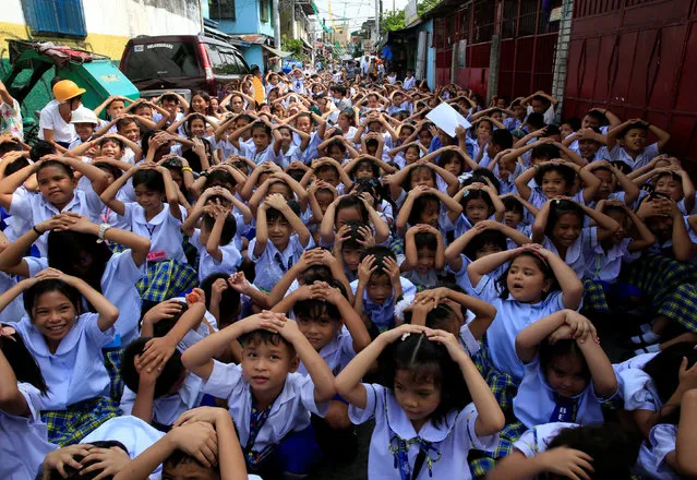 Students use their hands to cover their heads during an earthquake drill at the Baclaran Elementary School Unit-1 in Paranaque city, metro Manila, Philippines June 21, 2016. (Photo by Romeo Ranoco/Reuters)