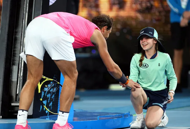 Spain’s Rafael Nadal passes a ball girl his head band after winning the match against Argentina’s Federico Delbonis in Melbourne, Australia on January 23, 2020. (Photo by Kai Pfaffenbach/Reuters)