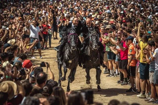Two “caixers” (horse riders) gallop together with their arms entwined during the training session for the “Jocs des Pla” (medieval tournament) during the traditional “Sant Joan” (Saint John) festival in Ciutadella de Menorca, Spain on June 24, 2022. (Photo by Matthias Oesterle/Rex Features/Shutterstock)