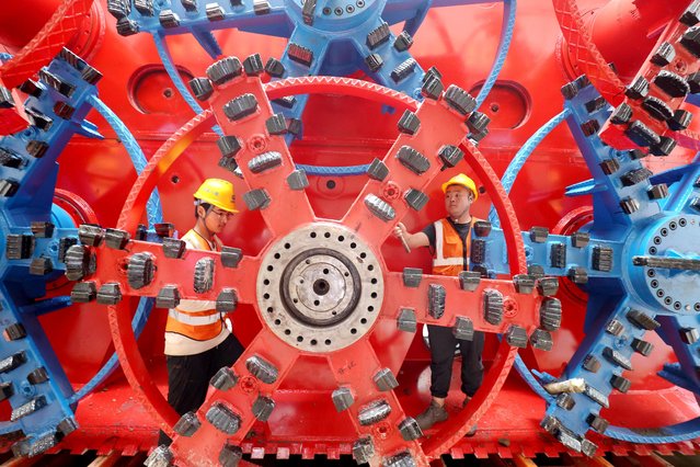 China Railway workers assemble a pipe jacking machine at the construction site of an underground railway station, in Huzhou, Zhejiang province, China on October 17, 2024. (Photo by Reuters/China Daily)