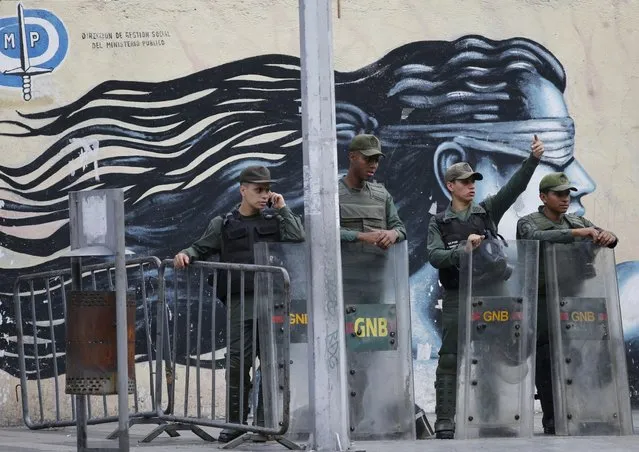 Venezuelan Bolivarian National Guards officers lineup outside of General Prosecutor headquarters in Caracas, Venezuela, Saturday, August 5, 2017. Security forces surrounded the entrance to Venezuela's chief prosecutor's office early Saturday ahead of a session of the newly-installed constitutional assembly in which the pro-government body is expected to debate the onetime loyalist turned arch critic's removal. (Photo by Ariana Cubillos/AP Photo)
