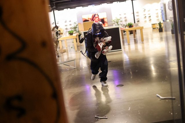 People loot a shoe store during celebrations after the Los Angeles Dodgers' victory over the New York Yankees to win the World Series in Los Angeles, California on October 31, 2024. (Photo by Daniel Cole/Reuters)