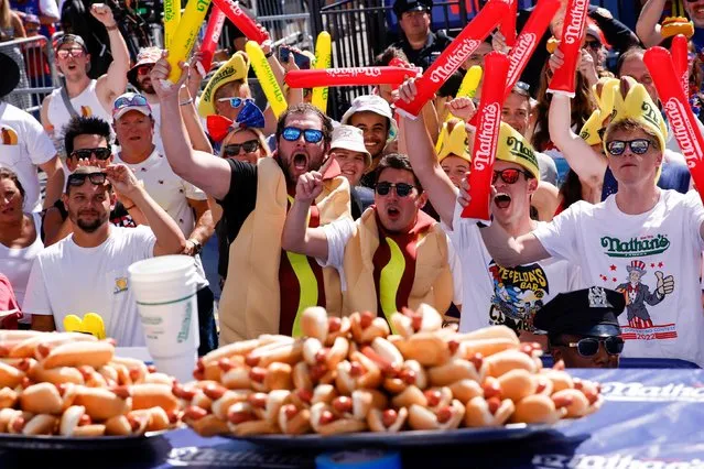 People react at Nathan’s Famous Fourth of July International Hot Dog Eating Contest as it returns to the flagship restaurant after the easing of COVID-19 restrictions, at Coney Island in New York, U.S., July 4, 2022. (Photo by Eduardo Munoz/Reuters)