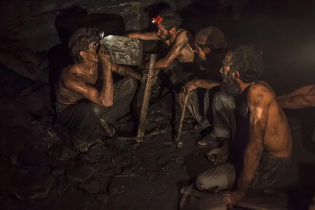 Miners take a break to drink water inside a coal mine in Choa Saidan Shah, Punjab province, April 29, 2014. (Photo by Sara Farid/Reuters)