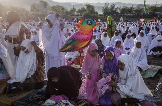 Indonesian muslim women attend Eid Al-Fitr prayer on “sea of sands” at Parangkusumo beach on July 6, 2016 in Yogyakarta, Indonesia. Eid Al-Fitr marks the end of Ramadan, during which Muslims in countries around the world spend time with family, offer gifts and often give to charity. (Photo by Ulet Ifansasti/Getty Images)