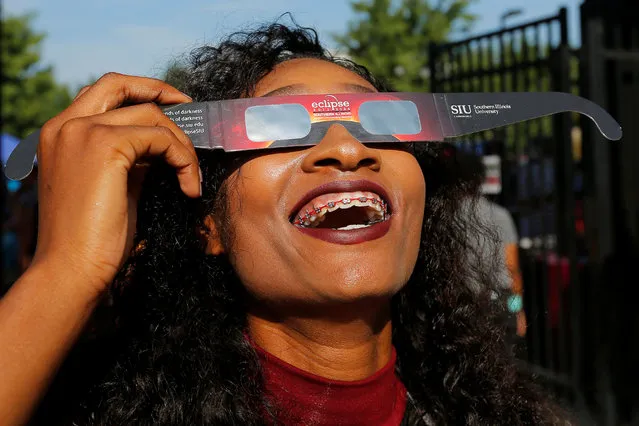 A cheerleader uses solar viewing glasses before welcoming guests to the football stadium to watch the total solar eclipse at Southern Illinois University in Carbondale, Illinois, U.S., August 21, 2017.  Location coordinates for this image are 37°42'25" N  89°13'10" W. (Photo by Brian Snyder/Reuters)