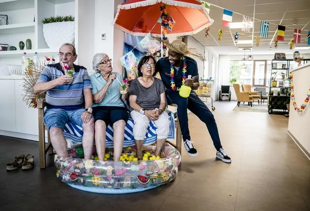 Residents of a care home sit with their feet in a swimming pool to cool off during a heatwave, in Zoetermeer, the Netherlands, on July 19, 2022. (Photo by Bart Maat/ANP via AFP Photo)