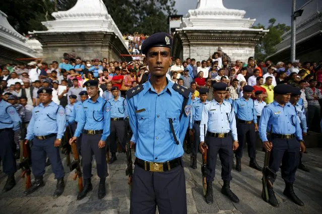 Nepali police stand during a cremation ceremony of Senior Superintendent of Police (SSP) Laxman Neupane, who was killed in Monday's protest, at Tikapur in Kailali district, Nepal August 25, 2015. (Photo by Navesh Chitrakar/Reuters)